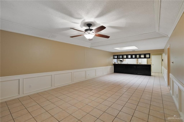 301 E Ln Vista Ave Unit Ut26, Mcallen, TX 78501 - spare room with a decorative wall, a textured ceiling, a ceiling fan, crown molding, and wainscoting
