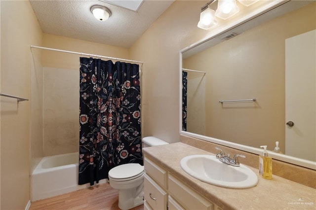 301 E Ln Vista Ave Unit Ut26, Mcallen, TX 78501 - bathroom featuring wood finished floors, a textured ceiling, toilet, vanity, and shower / bath combination with curtain