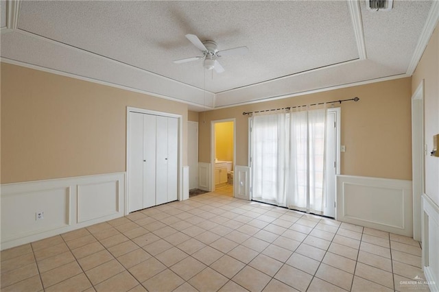 301 E Ln Vista Ave Unit Ut26, Mcallen, TX 78501 - empty room featuring a decorative wall, a wainscoted wall, a textured ceiling, ceiling fan, and light tile patterned floors