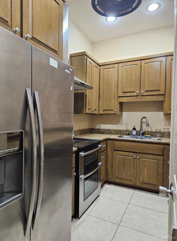 3109 S Casa Linda St, Mcallen, TX 78503 - kitchen with appliances with stainless steel finishes, a sink, brown cabinetry, and light tile patterned floors