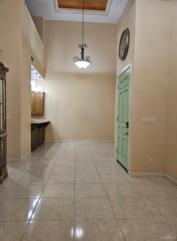 3109 S Casa Linda St, Mcallen, TX 78503 - corridor featuring a towering ceiling, light tile patterned floors, baseboards, and a tray ceiling