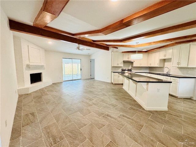 kitchen with ceiling fan, a center island, white cabinetry, and hanging light fixtures