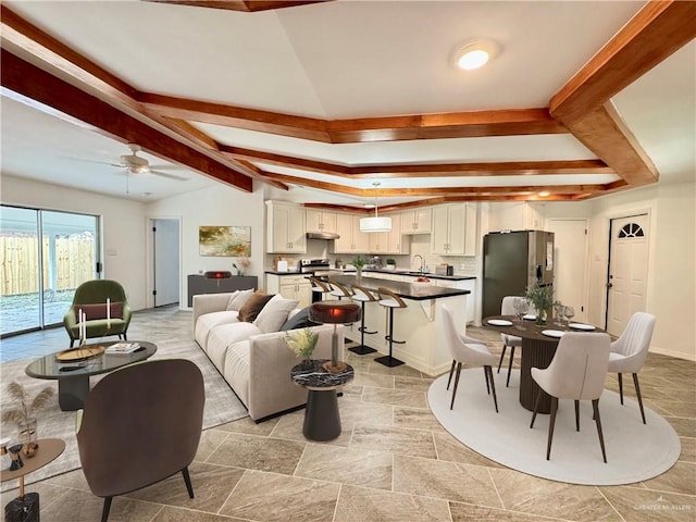 living room with ceiling fan, lofted ceiling with beams, and sink