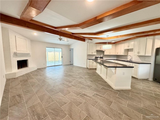 kitchen featuring ceiling fan, a center island, sink, pendant lighting, and white cabinets