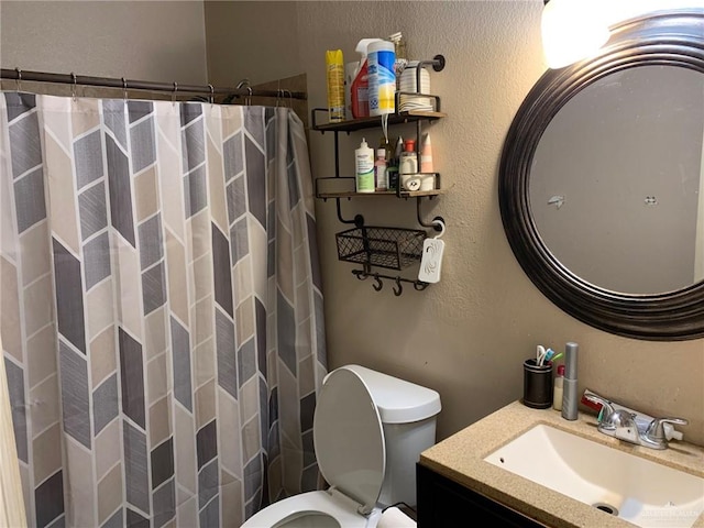 bathroom featuring vanity, toilet, and walk in shower