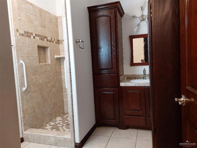 bathroom featuring a stall shower, baseboards, ceiling fan, tile patterned flooring, and vanity