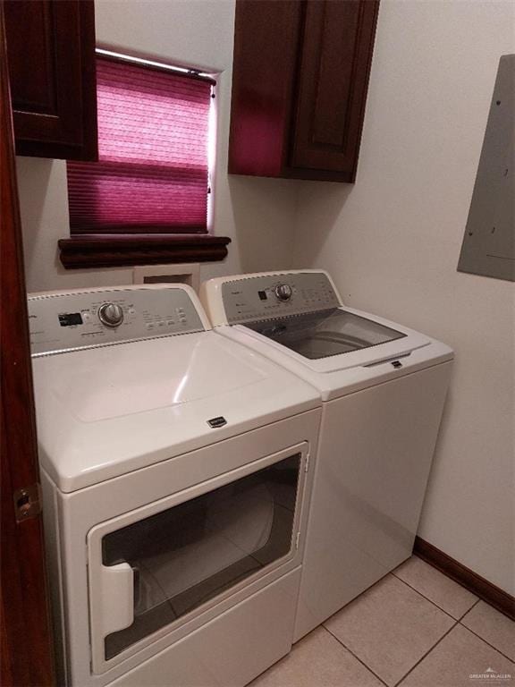 laundry area featuring light tile patterned floors, baseboards, cabinet space, electric panel, and washing machine and clothes dryer