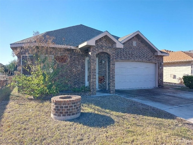 ranch-style home with an attached garage, driveway, roof with shingles, and brick siding