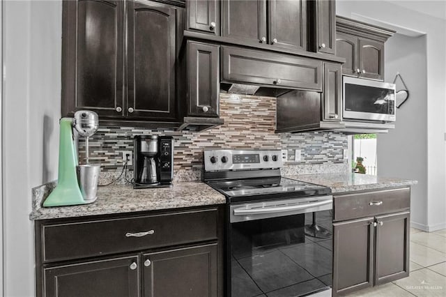 kitchen featuring light stone countertops, appliances with stainless steel finishes, backsplash, dark brown cabinets, and light tile patterned floors