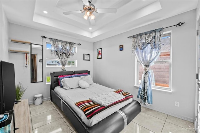 bedroom featuring a tray ceiling, ceiling fan, and light tile patterned flooring