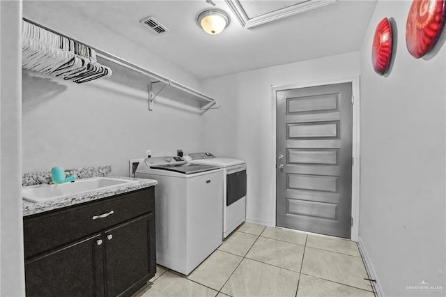 washroom featuring cabinets, washing machine and dryer, light tile patterned floors, and sink