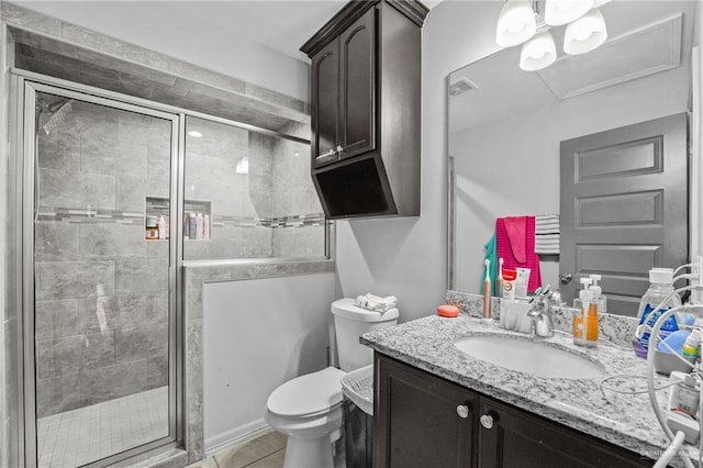 bathroom featuring tile patterned floors, vanity, an enclosed shower, and toilet