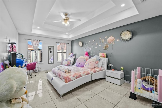 tiled bedroom featuring a raised ceiling and ceiling fan