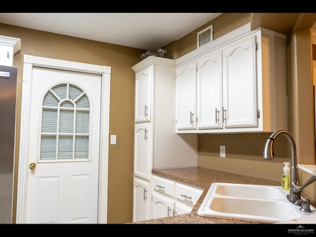 kitchen featuring white cabinetry and sink