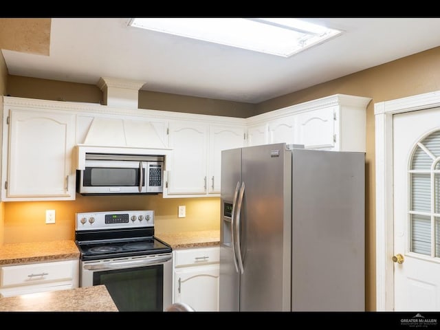 kitchen with white cabinets and appliances with stainless steel finishes