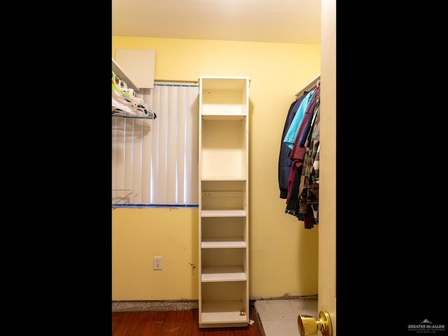 walk in closet with dark hardwood / wood-style floors