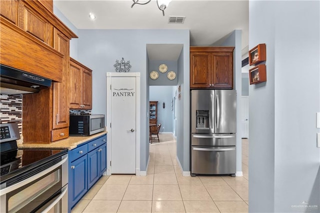 705 W Vinson Ave, Harlingen, TX 78550 - kitchen featuring custom exhaust hood, light stone counters, light tile patterned floors, stainless steel appliances, and decorative backsplash