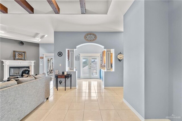 705 W Vinson Ave, Harlingen, TX 78550 - tiled living room featuring beam ceiling, a fireplace, and french doors