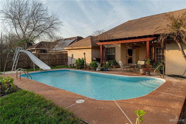 view of pool with a patio, ceiling fan, and a water slide