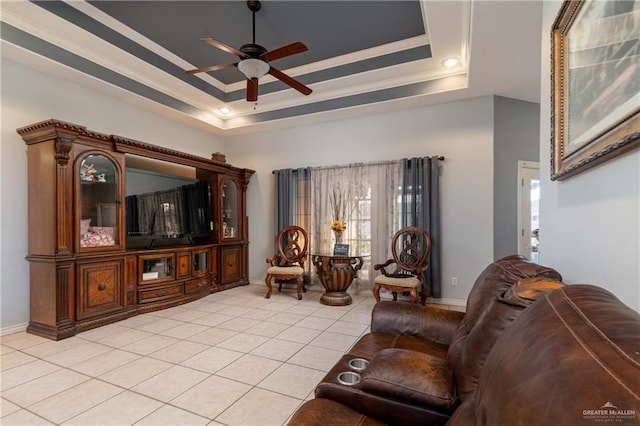 tiled living room featuring ornamental molding, ceiling fan, and a tray ceiling