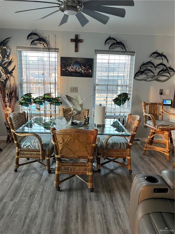 living area featuring ceiling fan, baseboards, and wood finished floors