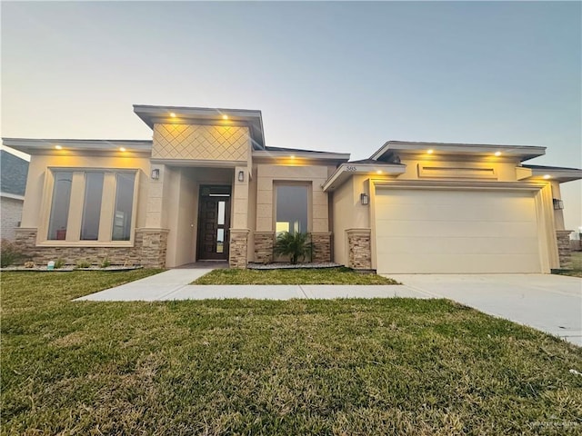 view of front of property featuring a garage and a lawn