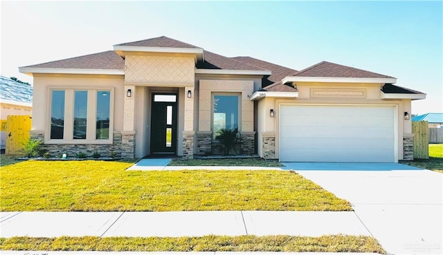 prairie-style home with a garage and a front yard