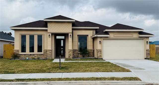 prairie-style home featuring a garage and a front lawn