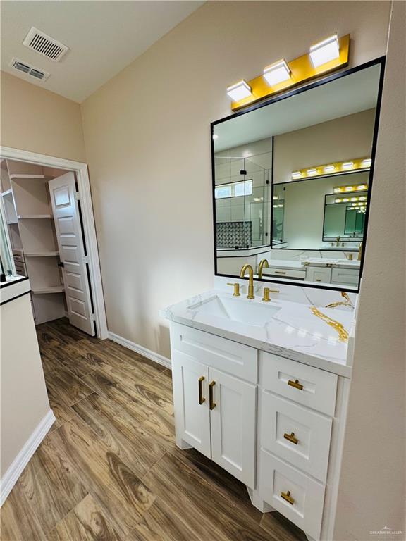 bathroom with vanity, hardwood / wood-style flooring, and a shower with shower door