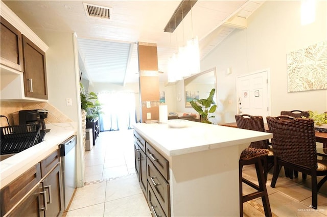 6608 Padre Blvd, South Padre Island, TX 78597 - kitchen with a breakfast bar, decorative backsplash, a kitchen island, hanging light fixtures, and light tile patterned floors