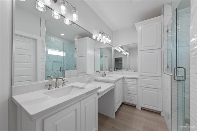 bathroom with wood-type flooring, an enclosed shower, and vanity