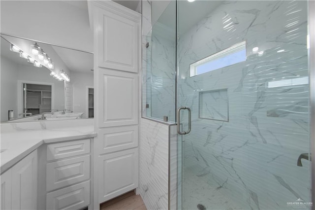 bathroom featuring walk in shower and vanity