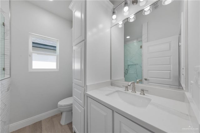 bathroom featuring walk in shower, vanity, wood-type flooring, and toilet