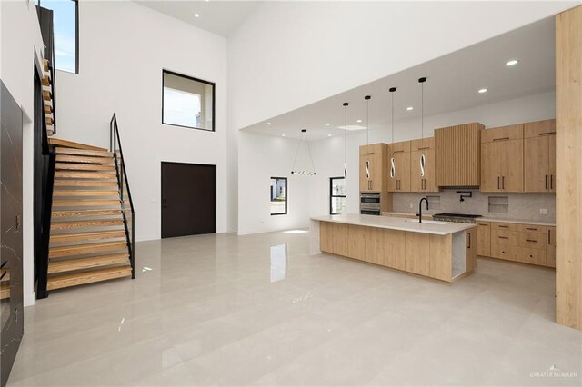 1620 S Ongar Ln, Edinburg, TX 78539 - kitchen featuring modern cabinets, a towering ceiling, a sink, light countertops, and a large island