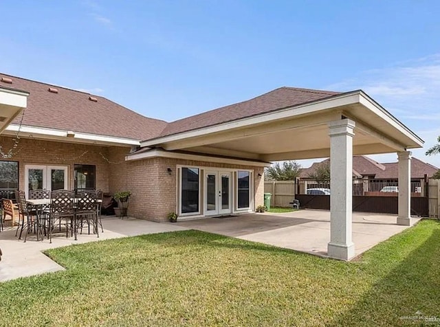 1806 E Flora Ave, Hidalgo, TX 78557 - back of property with french doors, a patio area, and brick siding
