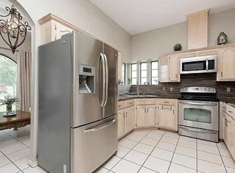 1806 E Flora Ave, Hidalgo, TX 78557 - kitchen featuring stainless steel appliances, healthy amount of natural light, light tile patterned floors, and dark countertops