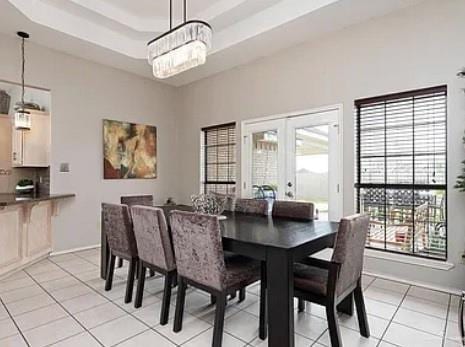 1806 E Flora Ave, Hidalgo, TX 78557 - dining area with light tile patterned floors, a chandelier, and a tray ceiling
