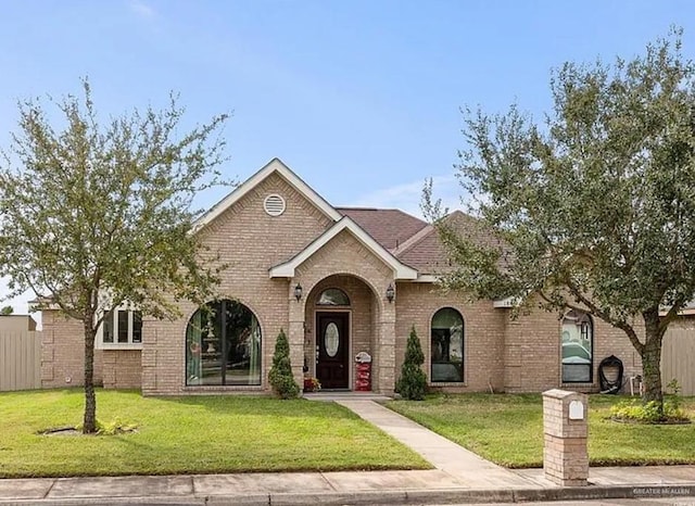 1806 E Flora Ave, Hidalgo, TX 78557 - view of front of home featuring a front lawn and brick siding