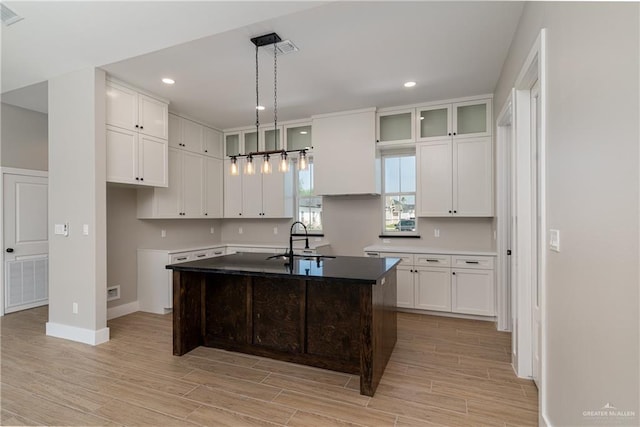 kitchen featuring white cabinetry, recessed lighting, light wood-type flooring, and a sink