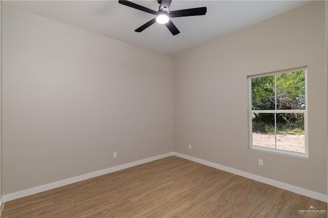 empty room featuring a ceiling fan, baseboards, and light wood-type flooring