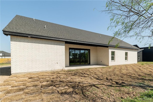 rear view of property with brick siding and a patio