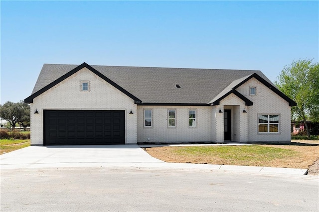 view of front of home featuring an attached garage, brick siding, and driveway