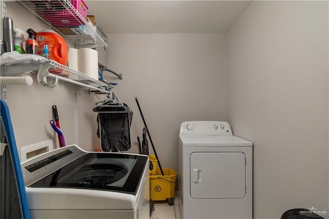 laundry room featuring tile patterned flooring and separate washer and dryer