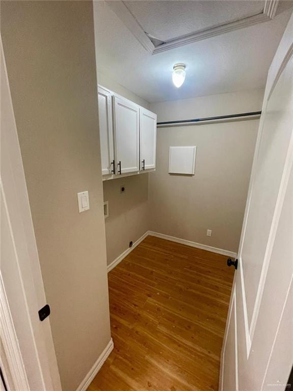 laundry room with light hardwood / wood-style flooring, cabinets, a textured ceiling, and hookup for an electric dryer