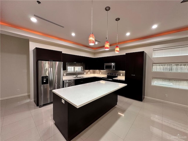 kitchen featuring decorative backsplash, appliances with stainless steel finishes, decorative light fixtures, a center island, and light tile patterned flooring