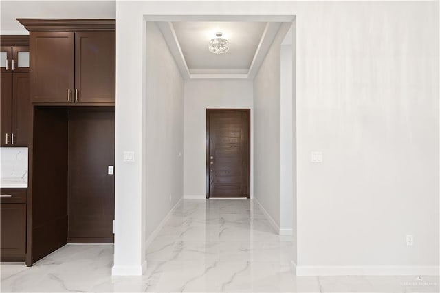 entryway with marble finish floor and baseboards