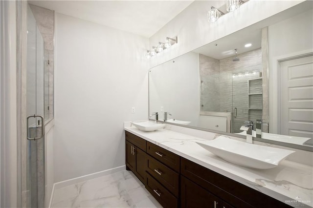 full bathroom featuring marble finish floor, baseboards, a sink, and a stall shower