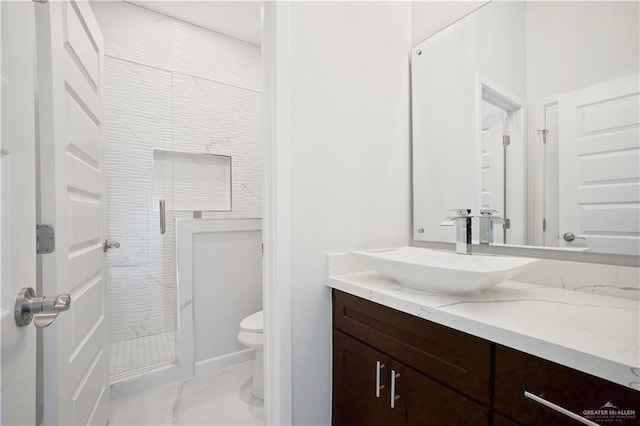 full bathroom featuring toilet, marble finish floor, a shower stall, and vanity