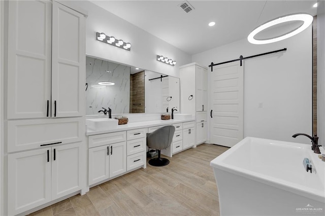 1320 S Cesar Chavez Rd, Edinburg, TX 78542 - bathroom featuring a soaking tub, double vanity, a shower, wood finished floors, and recessed lighting