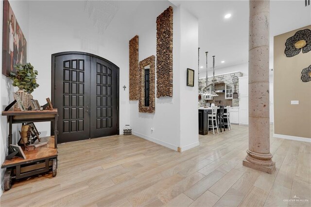 1320 S Cesar Chavez Rd, Edinburg, TX 78542 - foyer with decorative columns, a towering ceiling, light wood finished floors, recessed lighting, and arched walkways